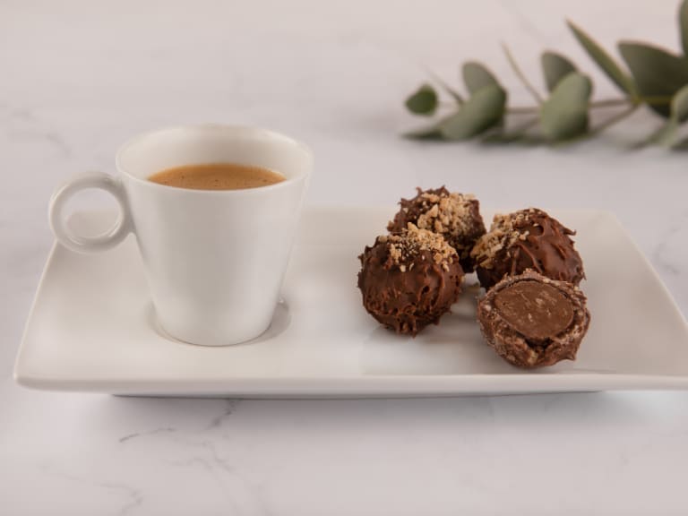 Foto de café espresso, em prataria branca, com bombons