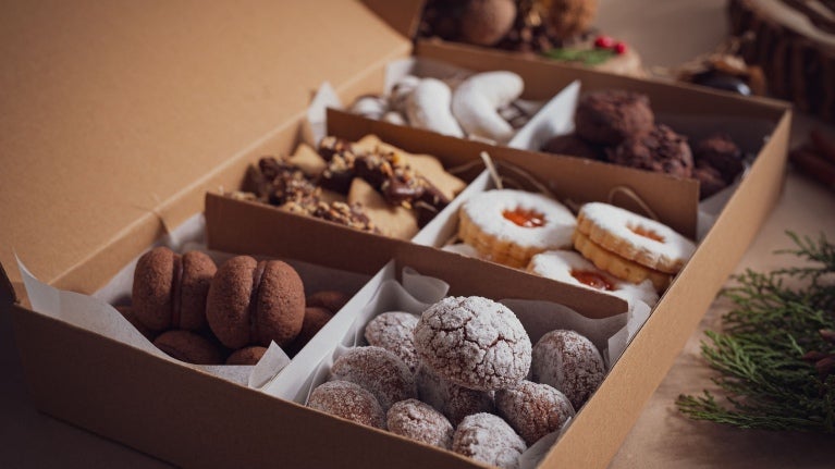 Imagem mostra vários tipos de biscoitos de natal, doces e saborosos em uma caixa.