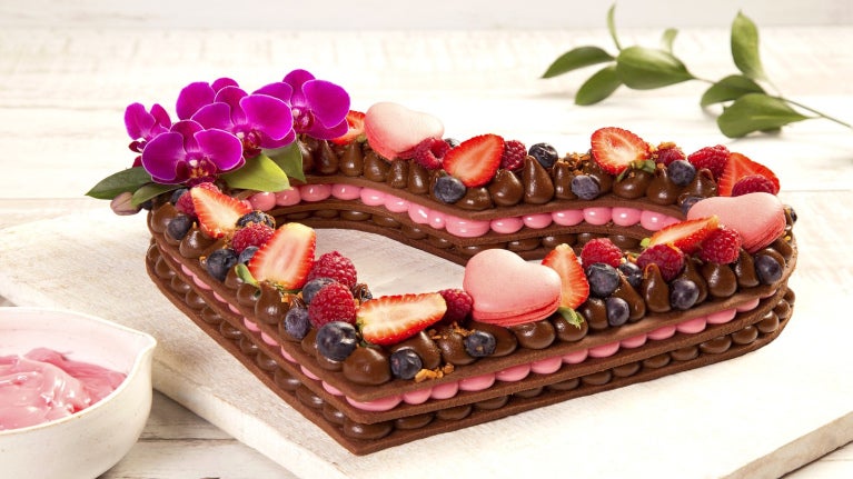 Bolo no formato de coração com recheio de frutas, balinhas e chocolate