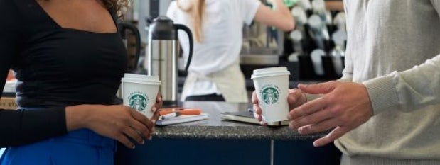 Pessoas conversando em um balcão de cafeteria tomando produtos starbucks
