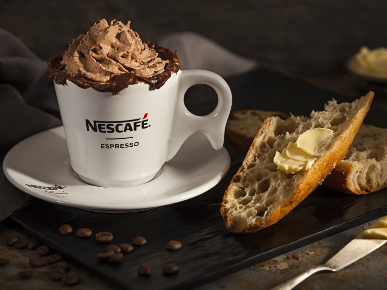 Xícara de Nescafé espresso com espuma e borda cremosa de chocolate