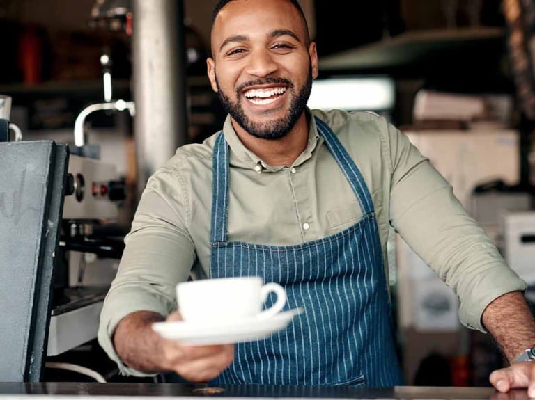 Barista mostrando uma xícara de café feita pelas máquinas de café