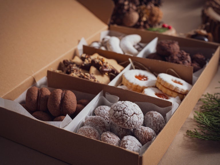 Imagem mostra vários tipos de biscoitos de natal, doces e saborosos em uma caixa.