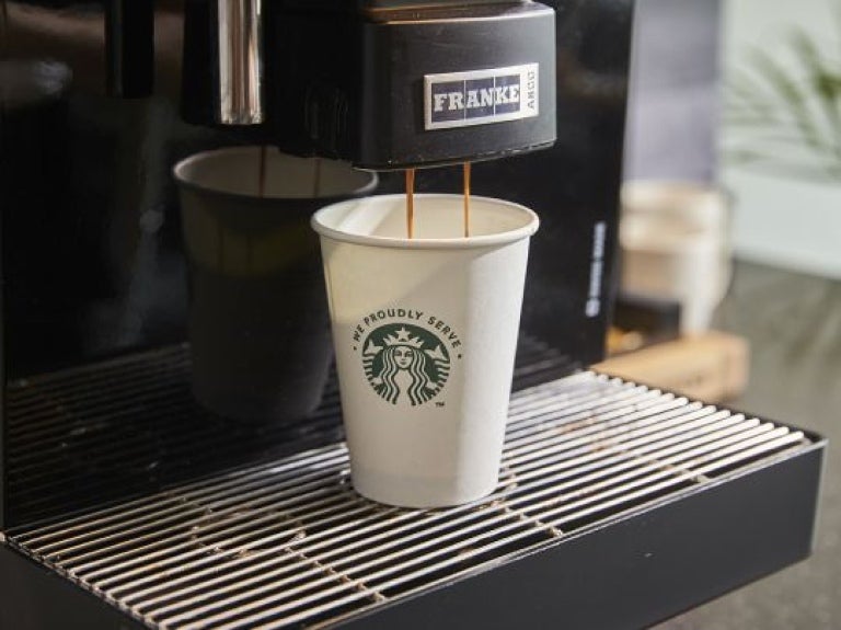 Máquina starbucks preparando um café no copo starbucks