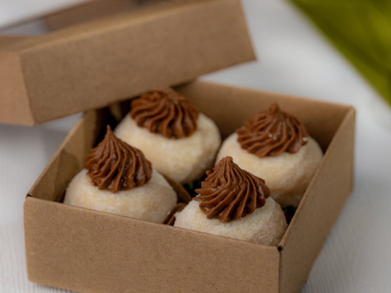 Caixa com quatro brigadeiros brancos com cobertura de chocolate