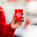 Mão segura copo térmico vermelho da marca KitKat - Nestlé Professional