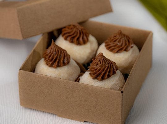 Caixa aberta com quatro brigadeiros de ninho gourmet recheados com Alpino para vender - Nestlé Professional