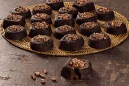 Imagem mostra diversos brownies recheados em uma bandeja sob uma bancada de madeira – Ideias para Páscoa 2024.