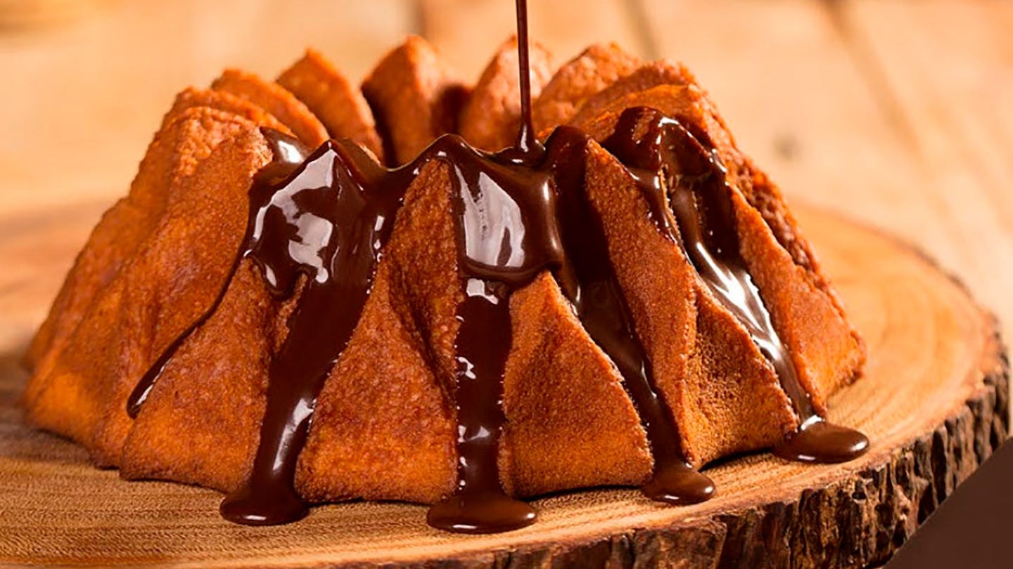Imagem mostra cobertura de chocolate caindo e escorrendo sobre bolo – Ideias para Páscoa 2024.
