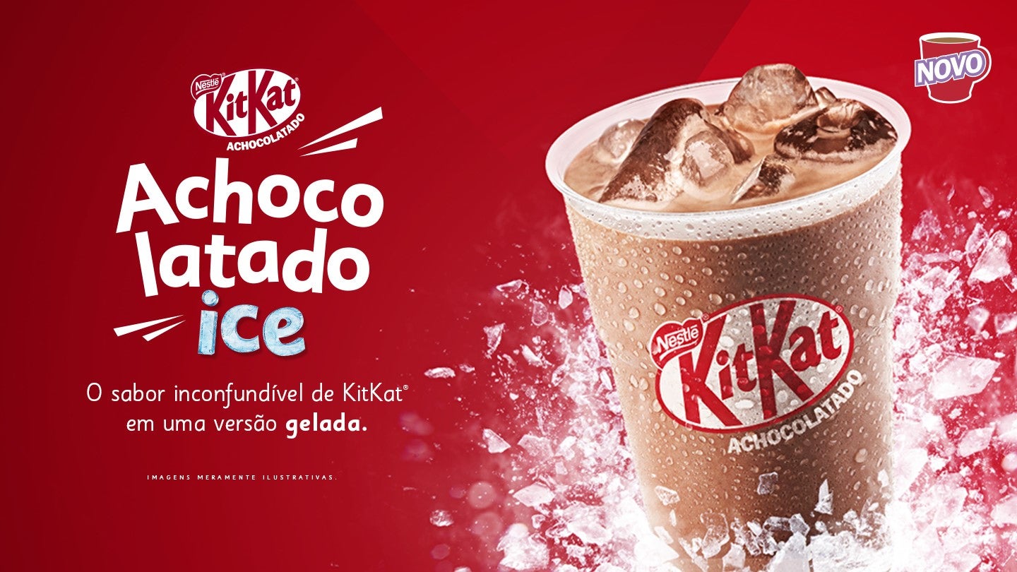 Copo de bebida achocolatada gelada KitKat com cubos de gelo, em fundo vermelho promocional.