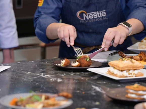 Profissional da gastronomia mostrando um prato desenvolvido pelo profissional